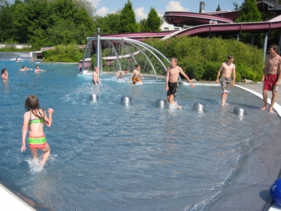 Sprühpergola und Wasserigel und Sitzpoller im Strandbereich.