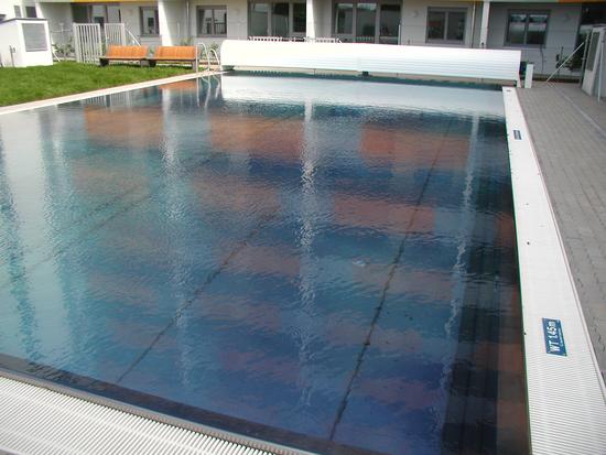 Schwimmbecken für Wohnhausanlage mit Schwimmbeckenabdeckung.