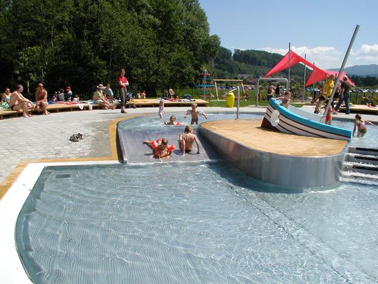 Kinderplanschbecken, im Hintergrund der Kinderbereich mit Segel als Schattenspender.